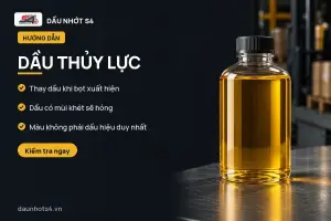 Dầu Thủy Lực: Chai dầu có màu vàng, đứng trên bề mặt kim loại sáng bóng.